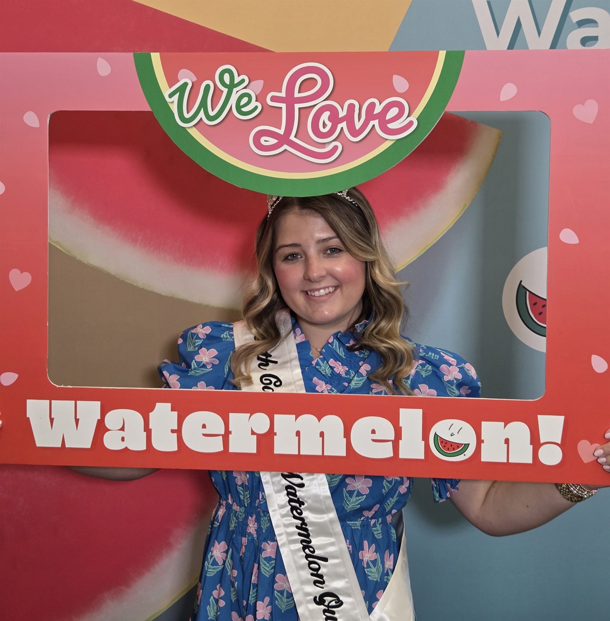 Lilah Byrum framed by a "We Love Watermelon!" photo board