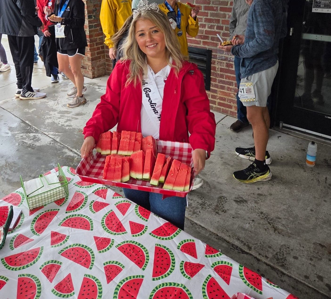 Lilah Byrum carrying a tray of watermelon slices at an event